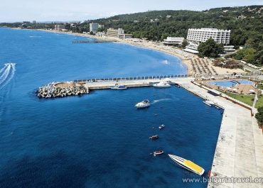 Aerial view of beach and pier, showcasing the scenic beauty of the coastline from a higher perspective.