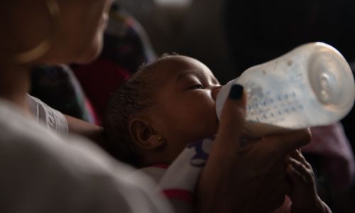 Baby drinking bottle of breast milk