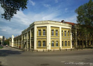 Yellow building with white trim against blue sky.