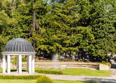 A serene white gazebo nestled in a picturesque park, offering a tranquil spot for relaxation and gatherings.