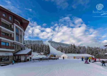 A ski resort with skiers and snowboarders enjoying the slopes on a sunny day.