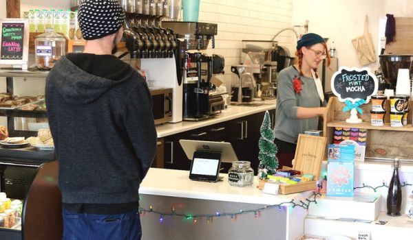 Person ordering coffee from a barista