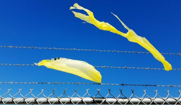 Plastic bag pollution caught on a fence