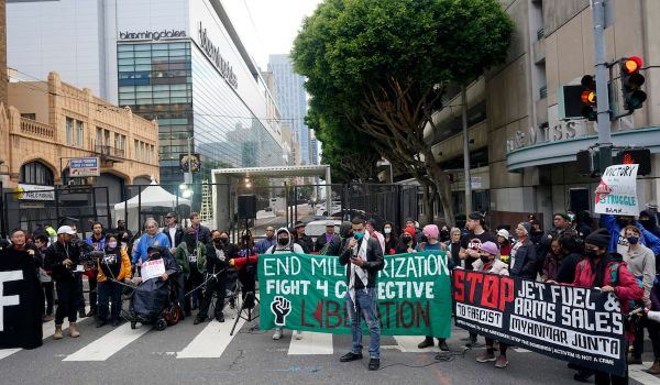 A crowd of protesters hold signs