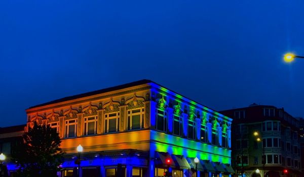 Blue, green and orange light reflects on building