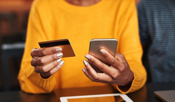 woman holding a credit card and phone