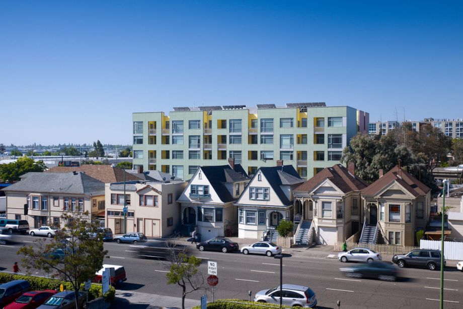 Street in Oakland where houses can be seen, with an apartment building behind them