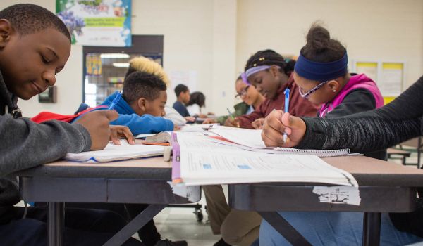 Students do homework around a large table