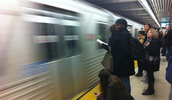 passengers wait to board a subway in Toronto