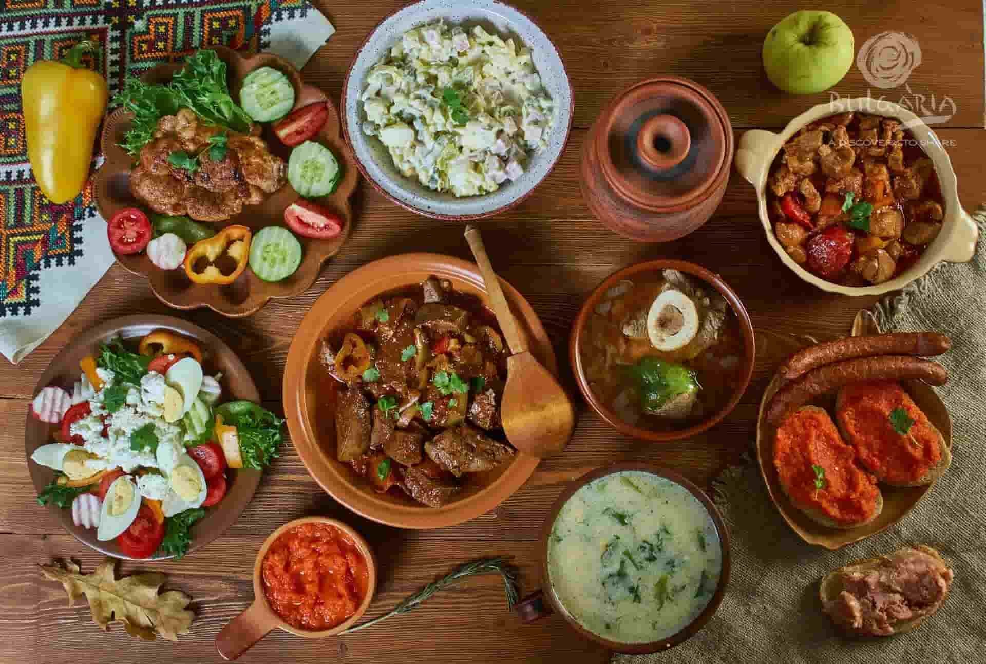 A table displaying a variety of food items, including fruits, vegetables, meats, and desserts.