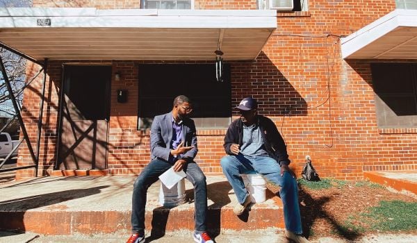 Mayor Woofin sits outside of a building with a resident of Birmingham