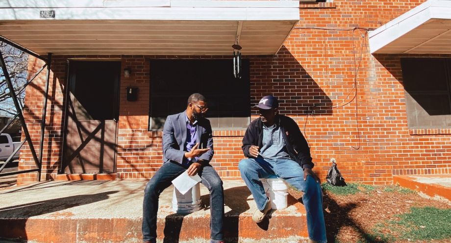 Mayor Woofin sits outside of a building with a resident of Birmingham